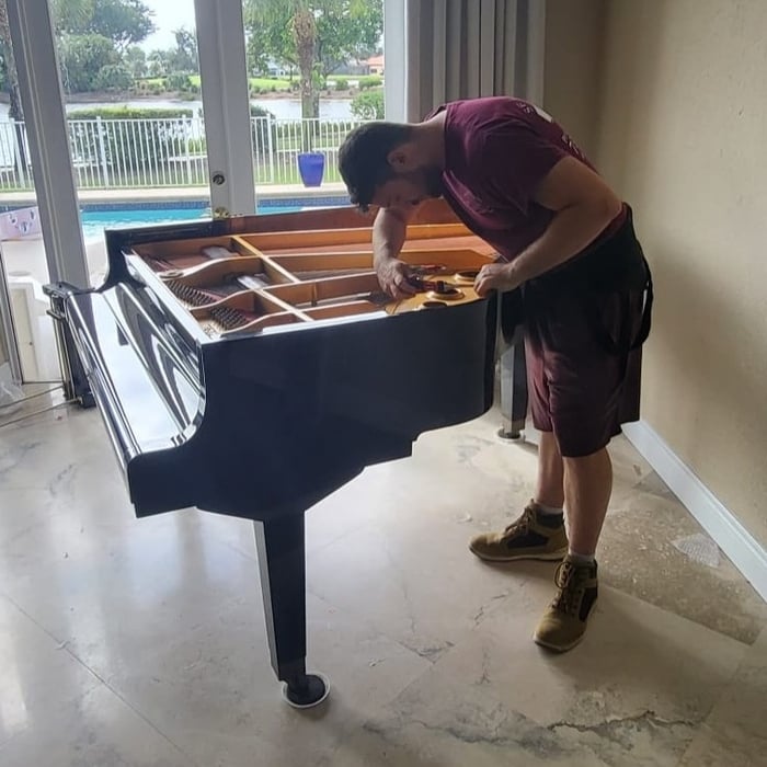 Our expert mover delicately disassembling a piano, ensuring a harmonious move for your cherished instrument. We handle your instrument with care and precision, so it reaches its new home in great shape. Trust us to orchestrate your piano move with expertise!