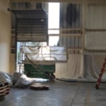 Spray foam application in progress on warehouse walls.