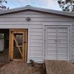 Outdoor storage building with attached dog kennel construction