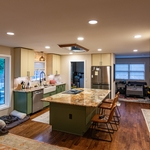 What a transformation. Five-person island, new hood on ceiling, more counters, recessed refrigerator...this kitchen has it all!
