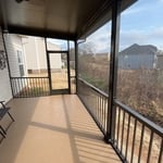 Basic patio to covered, screened-in porch with aluminum railing, gutters, and durable screening.