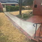 Poured concrete walkway bordered by brick.