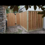 Nice shadow box fence with rotboard and arched gate.