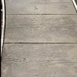 Colored and stamped concrete with antiquing color release. Stamp is vintage wood plank pattern.