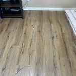 Before- Living room floor is damaged and needs repairing.