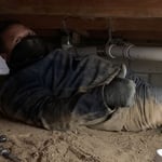 Ruben installs a new drainage system under a customers home. Working in a crawl space is rough, but we do what is needed.