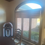 Interior view of the arched feature window, showing rich wooden interior framing that adds warmth and elegance to the space. The window brings in natural light and offers a beautiful view of the outside, blending functionality with stylish interior design.