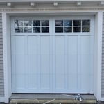 Completed garage door installation – brand new insulated door with decorative windows.