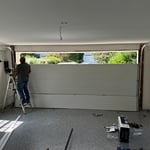 Technicians installing a new insulated garage door with a smart opener system. The project involved removing the old door, preparing the space, and ensuring a perfect fit for enhanced durability and functionality.