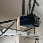 Close-up of a newly installed Chamberlain garage door motor, showcasing its sleek design and advanced technology. The motor is securely mounted and wired for optimal performance, providing smooth and quiet operation with smart connectivity features.