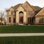 Transitional Home Exterior - Beige Brick Dark Wood Front Door With Large Window Panels