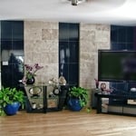 an eclectic family room with a two toned tile accent wall and light hardwood floors