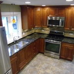 a traditional style kitchen with medium stained wood cabinetry and stainless steel appliances
