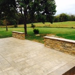 stamped concrete patio with low stone wall
