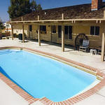 large back yard pool with brick border
