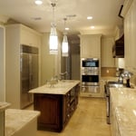 Onyx counters, white cabinets and travertine tile floor