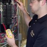An employee testing a circuit for power.