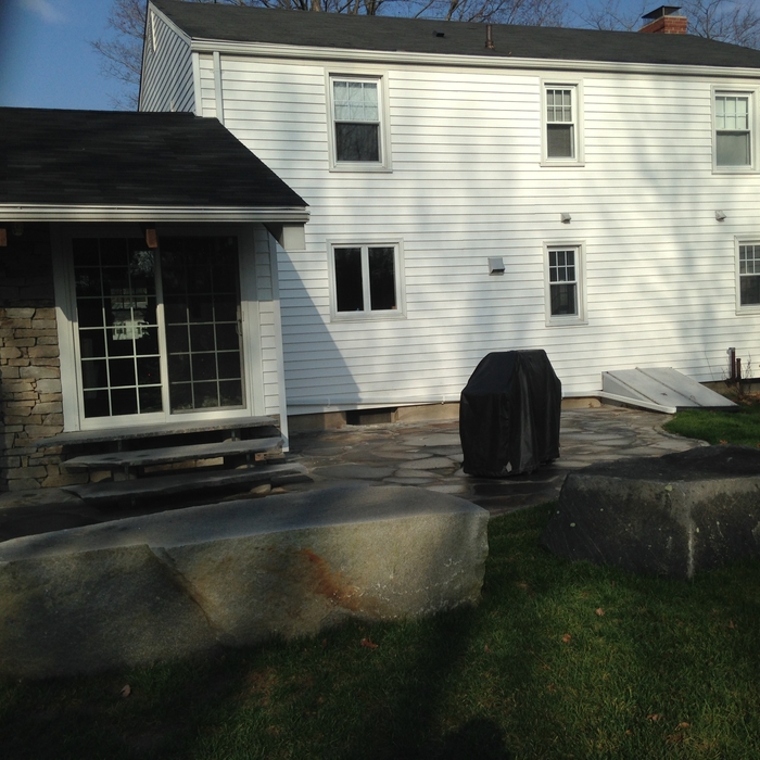 A flagstone patio with natural rock benches and steps causes the patio to blend in to its surroundings