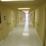 a commercial hallway with yellow walls and white linoleum floors