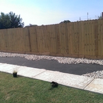 New cement walkway and wood privacy fence. Cobble rock edging