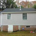 grey asphalt shingle house in wooded landscape