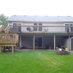 an open backyard deck with a u shaped deck staircase leading to backyard