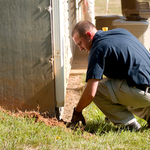 Technician inspecting depth of trench.