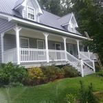 a two story home exterior with a large covered patio