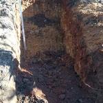 Checking grade on hole for septic tank.
