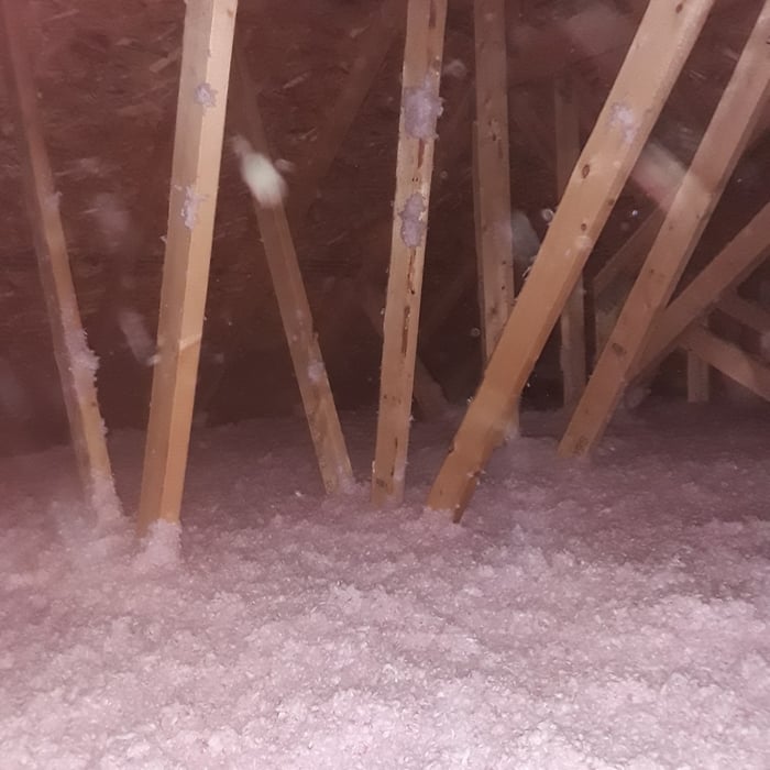 Attic insulation added around dense truss work.