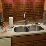 Traditional kitchen with quartz countertop, stainless steel kitchen sink, and oak wood cabinetry