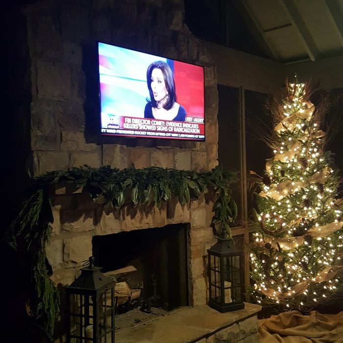 stacked stone fireplace surround with raised hearth and tv