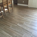 Traditional dining room with wood look tile flooring, brown wall paint, and white wood shutters