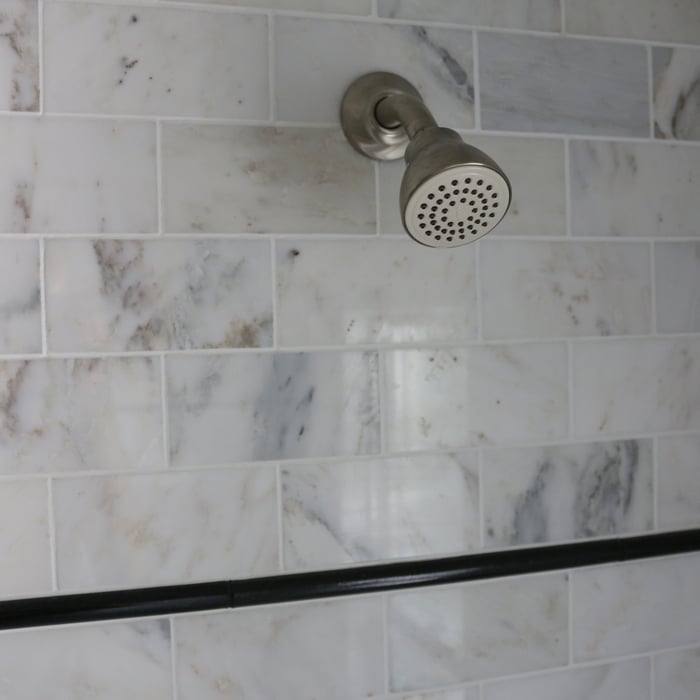 Marble subway tile tube surround with accent