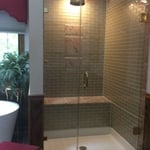 Glass tile shower stall with frameless glass doors
