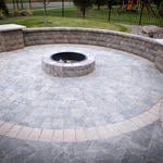 This paver patio with fire pit and sitting wall