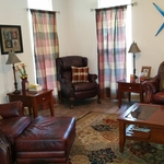 Masculine living room with plaid curtains and leather couches.