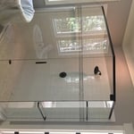 Frameless shower with header and towel bars