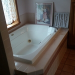 Traditional bathroom with drop in jetted tub with tile surround