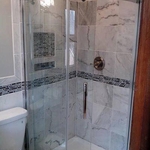 marble shower wall and glass door