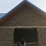 Standing seam roof system and finished wood soffit