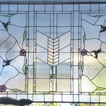 Large window with plumeria and hummingbirds.